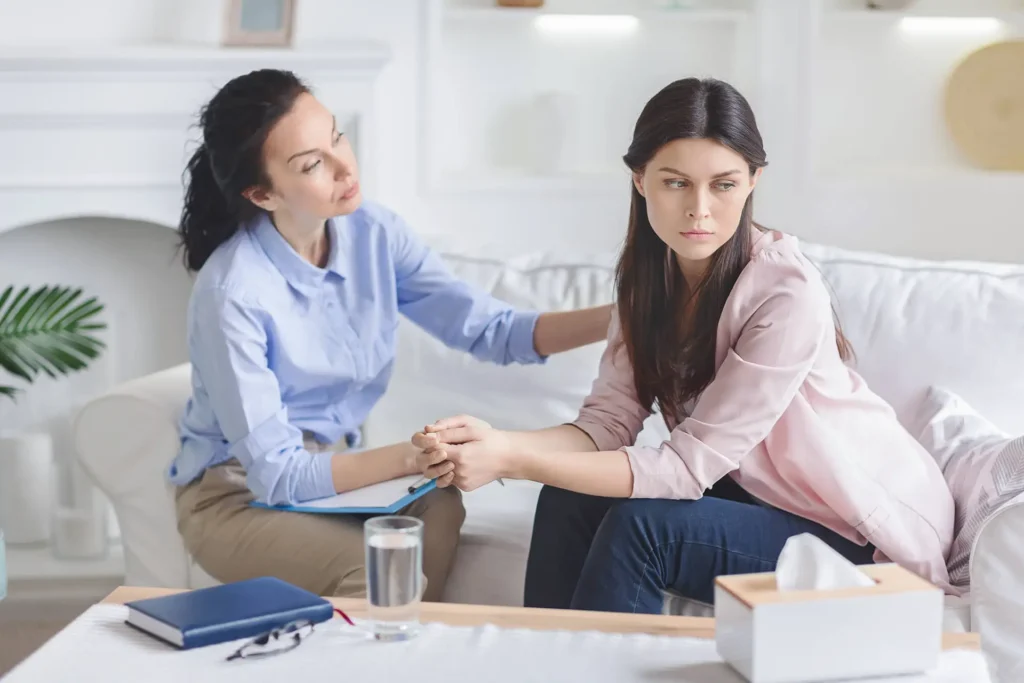 Mujer recibiendo apoyo psicológico durante una sesión de terapia tras una ruptura de pareja.